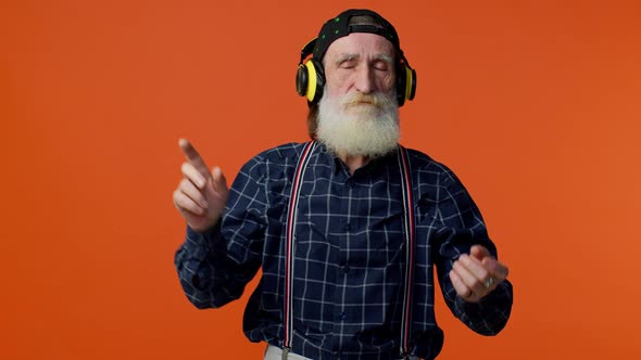 Senior Man Listening Music on Headphones Dancing Disco Fooling Around Having Fun Gesticulating Hands