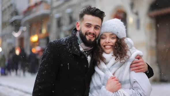 A Man and a Woman are Standing in the Center of the City in a Snowfall