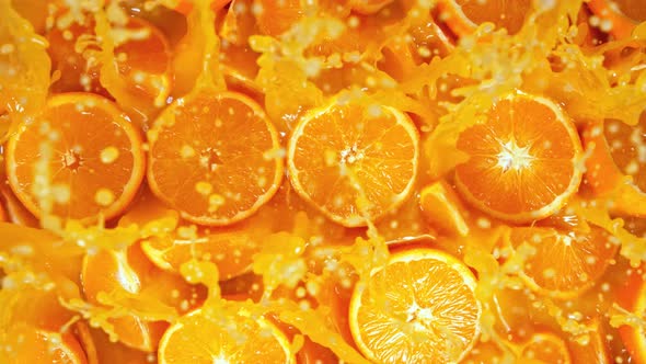 Super Slow Motion Shot of Fresh Orange Juice Splashing Through Orange Slices at 1000Fps