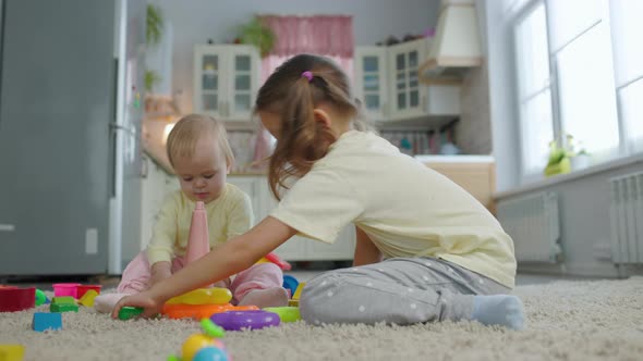 Two Sisters Girls Children Play Toys In The Room At Home