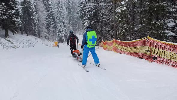 Mountain rescuers transporting an injured skier, going downhill after first aid / Videohive, Stock footage, Medical