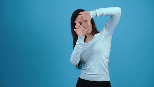 The Curious Young Woman Analyzes in Front of Her with the Help of the Hands She Places in Her Eyes