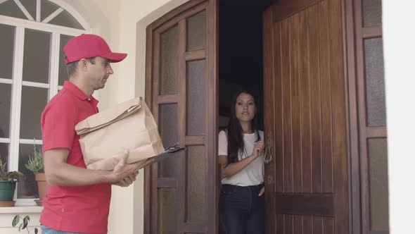 Male Courier in Red Uniform Knocking at Door