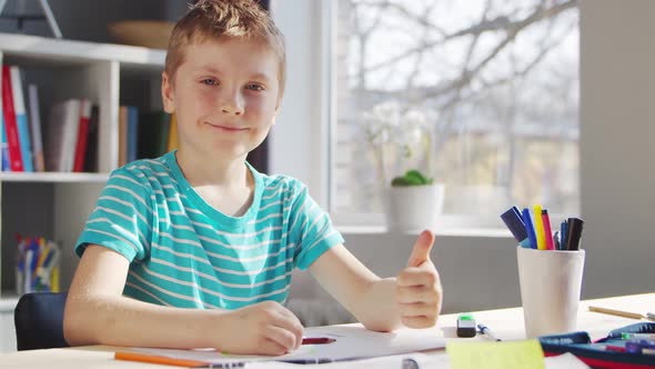 Boy is Doing  Homework at the Table. Cute Child is Learning at Home.