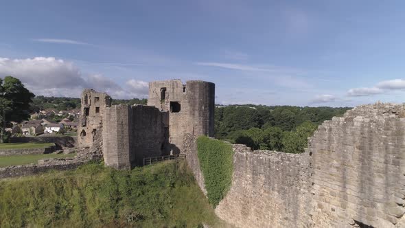 Aerial rise up shot looking north west over Bernard Castle walls, revealing the town and trees