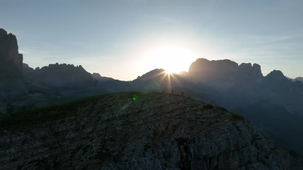 Hikers trekking in the Dolomites mountains at sunrise