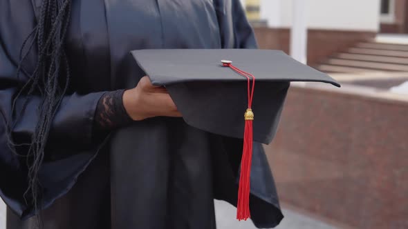 Master's Hat with a Red Tassel on the Hand of a University Graduate