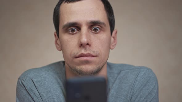 Shocked Man Looking at Mobile Phone