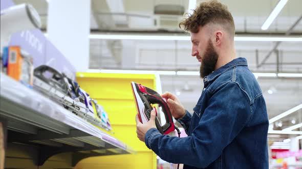 Man is Going to Buy Iron in Appliance Store