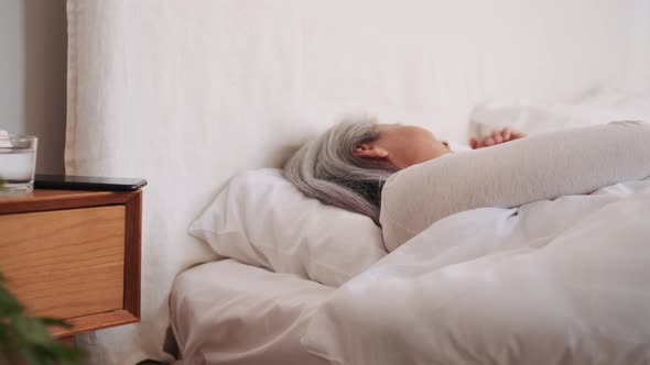 Happy Asian woman sleeping and waking up