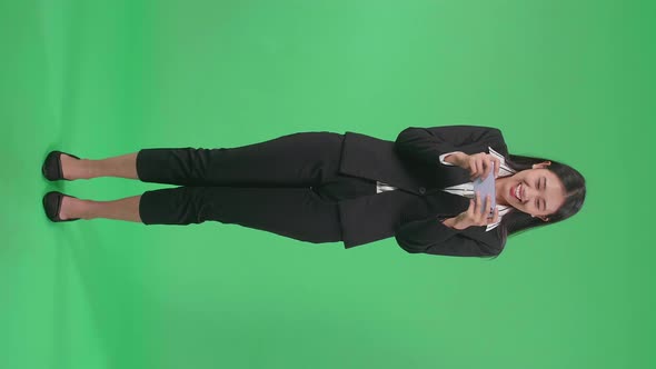 Full Body Of Asian Business Woman Celebrating After Winning Game On Mobile Phone On Green Screen