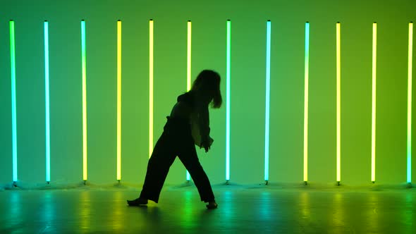 Flexible Professional Female Dance in a Studio Lit By Bright Neon Lights