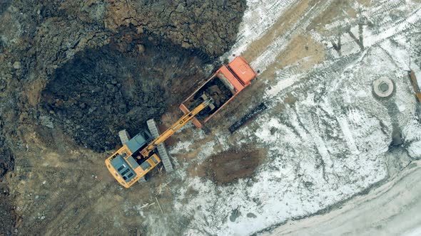 Tractor Loads a Truck with Sand at a Career. Heavy Machinery at a Construction Site.