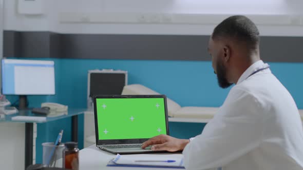 African American Physician Doctor Looking at Mock Up Green Screen Chroma Key Laptop Computer