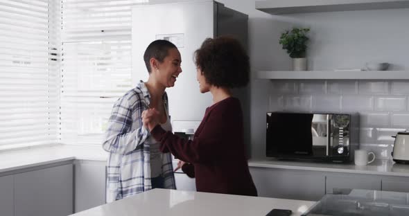 Lesbian couple dancing in kitchen