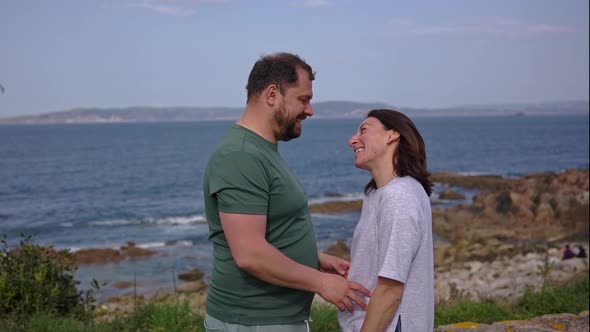 A Man and a Woman Pair Hug Near the Ocean