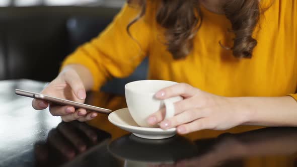 Woman Drinking Coffee in Cafe and Using Smartphone, Chatting in Social Networks