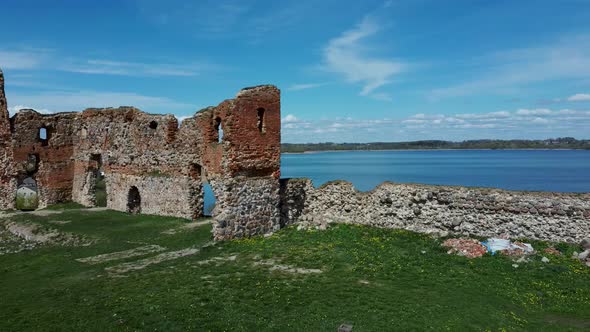 Aerial View of the Ludza Medieval Castle Ruins on a Hill  Big Ludza Lake. Camera Moves Sideward