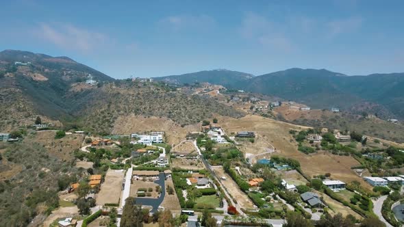 Drone camera shoots the canyon and settlement at the foot of the mountain in Malibu, California, USA