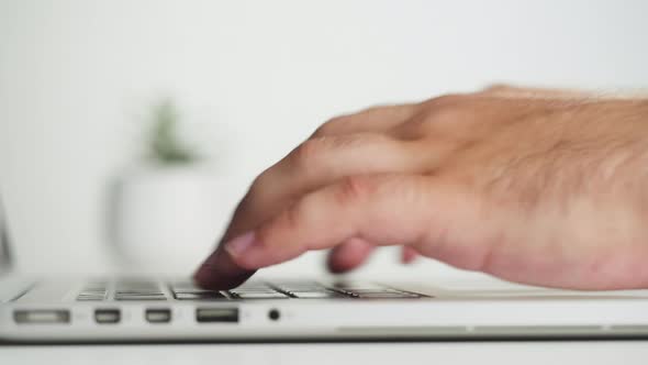 Male Hands Typing on Laptop Keyboard Closeup