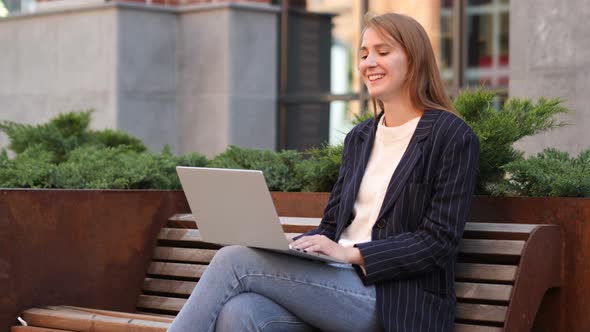 Web Video Chat on Laptop while Sitting on Bench Outside Office