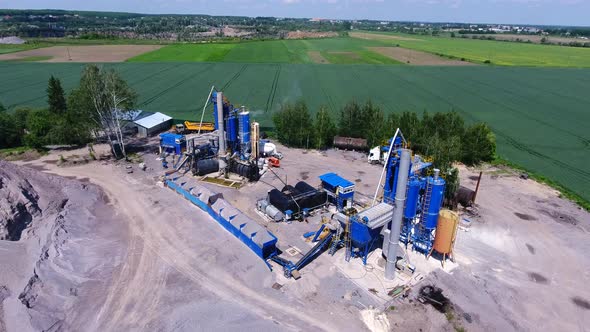 Asphalt production. High metal barrels and structures on the territory of the plant in the field.