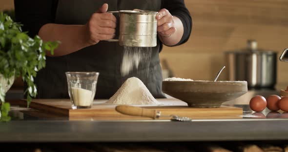 Woman sieving flour for home made Maultaschen dough