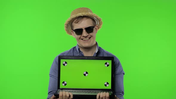 Portrait of Young Man Tourist in Sunglasses Showing Laptop. Chroma Key