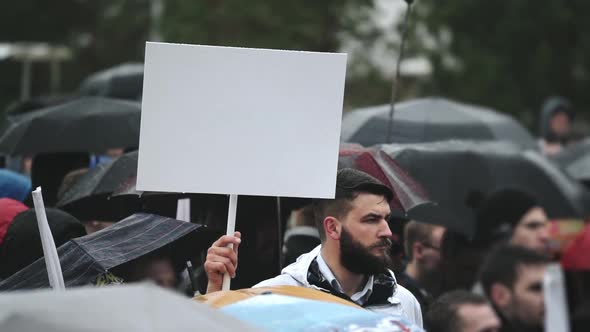 Sad Man on Funeral Holds Blank Advertising Copyspace Card Board Banner for Text