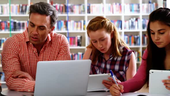 Teacher assisting schoolkids in their studies