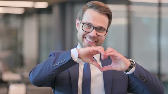 Portrait of Businessman showing Heart Sign by Hand