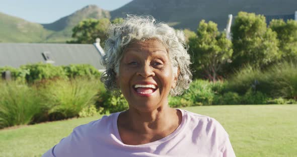 Portrait of happy senior african american woman in garden on sunny day at retirement home