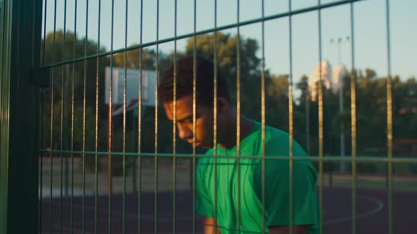 Pensive Basketball Player Standing on Outdoor Court