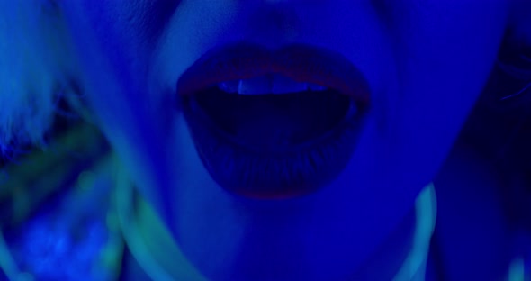 Close Up of the Lips of Young Woman with Lipstick in Blue Lighting, 