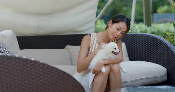 Woman play with her pomeranian dog at resort house