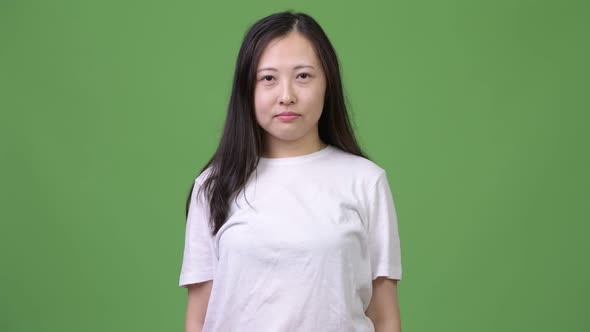 Young Happy Asian Woman Smiling Against Green Background