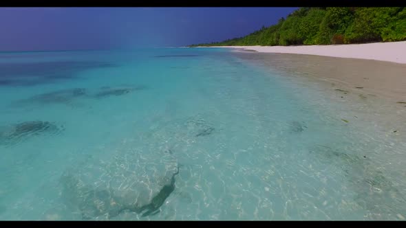 Aerial flying over panorama of idyllic coast beach trip by blue ocean with white sand background of 