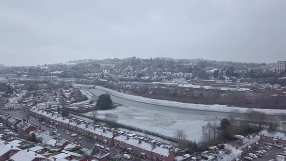 Sideways tracking drone shot of snowy Exeter over the River Exe