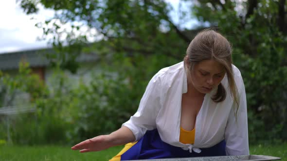 Attractive Plussize Woman Washing Face with Refreshing Water From Tub in Summer Garden