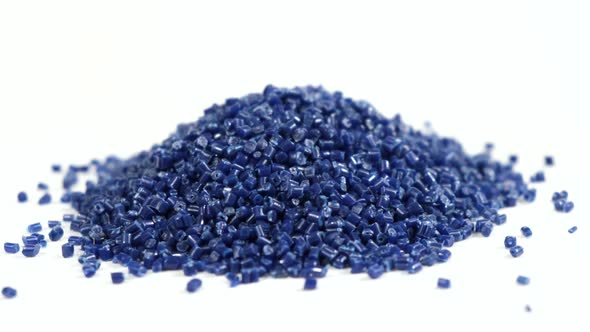 Secondary granule made of polypropylene. Dark blue plastic pellets crumbles on isolated background.