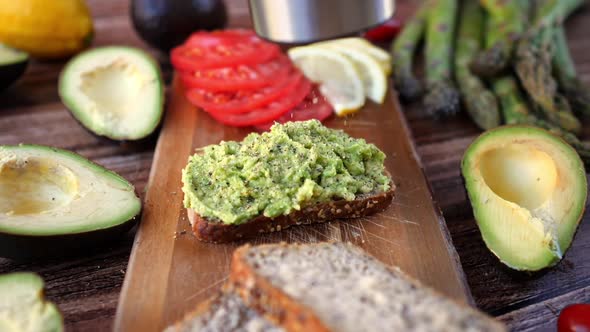 Salting Avocado Toast For Healthy Vegan Breakfast. Closeup. 