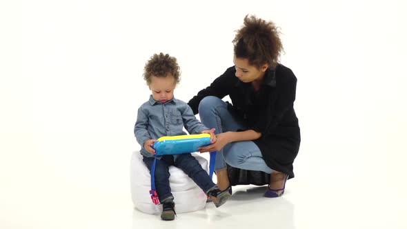 Afro American Mother Gives Her Baby an Interesting Toy, White Background, Slow Motion