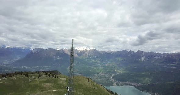 Aerial drone view of radio antenna cellular tower at the top of a hill.