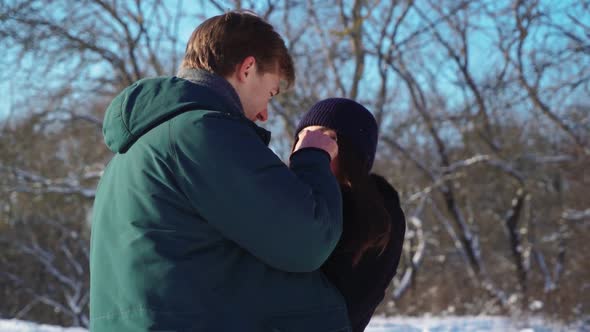 Lovers Stand and Hug in Winter Forest