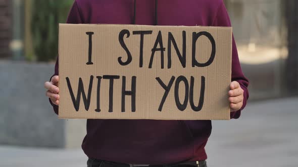 I STAND WITH YOU on a Cardboard Poster in the Hands of Male Protester Activist. Closeup of Poster