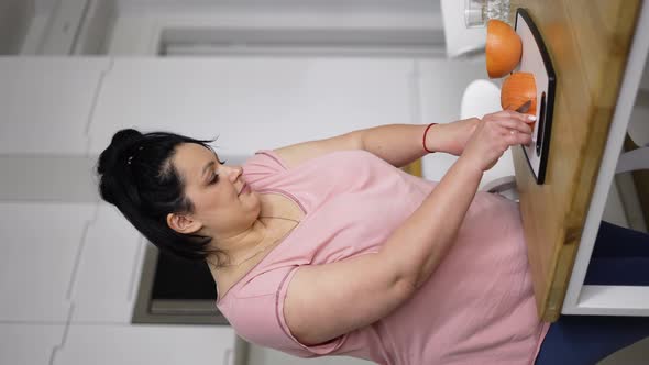 Attractive Overweight Woman Preparing Healthy Meal Cutting Grapefruit Closeup