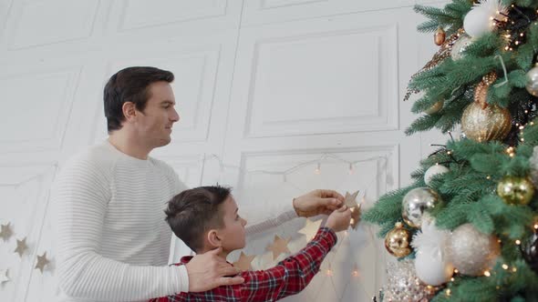 Smiling Father Decorating Living Room with Son Together.