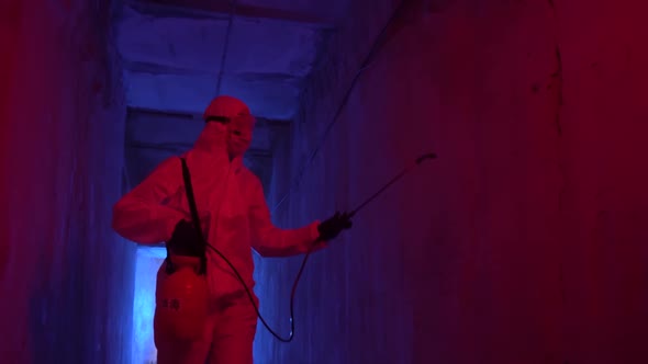Doctor epidemiologist in protective suit disinfects walls during quarantine with atomizer