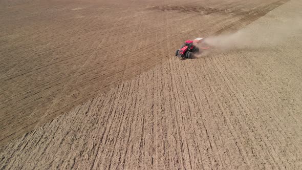 Tractor Cultivates Arid Farmland in a Desolate Prairie