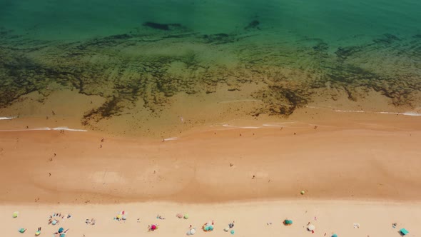 Tourist On Golden Sandy Shoreline Of Praia da Alagoa In Portugal During Summer. - Aerial Topdown